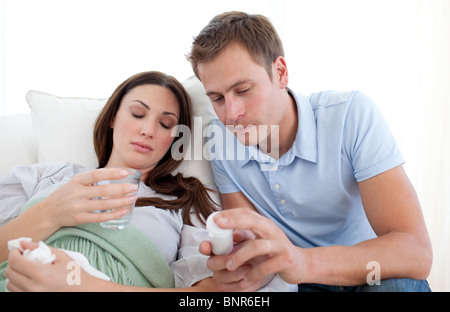 Giovane uomo alla ricerca dopo la sua moglie con l'influenza Foto Stock