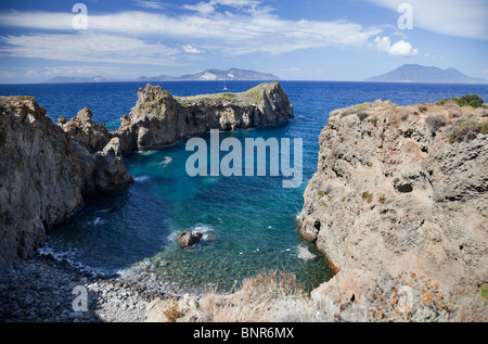 Riparata baia di Cala Junco nell isola di Panarea Isole Eolie. 3 Isole Eolie in distanza, Vulcano, Lipari,Salina Foto Stock