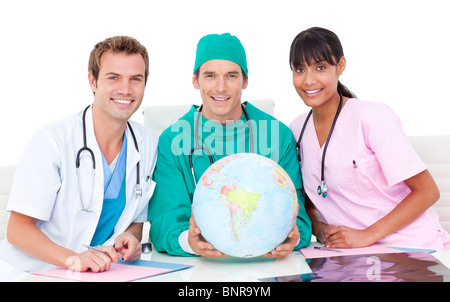 Il team medico con un globo Foto Stock