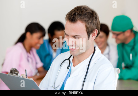 Giovane maschio medico sorridente verso la telecamera Foto Stock