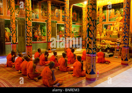 Il debuttante monaci cantando le preghiere della sera in un cambogiano pagoda - provincia di Kandal, Cambogia Foto Stock