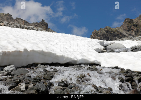 Neve di fusione a partire di un flusso in montagna nelle immediate vicinanze del ghiacciaio Rettenbach, Sölden, Tirolo, Austria nel mese di luglio Foto Stock