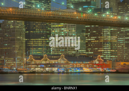 Ponte di Brooklyn, East River, South Street Seaport, e abbassare la skyline di Manhattan al crepuscolo in New York City. Foto Stock