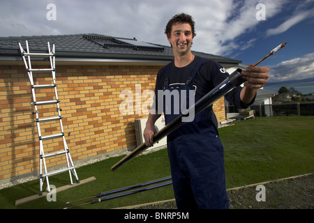 Artigiano qualificato installazione solare di acqua calda sistema a una casa, Nelson, Nuova Zelanda, la città con la più alta ore di sole Foto Stock