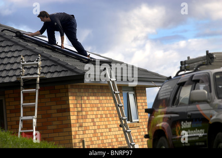 Artigiano qualificato installazione solare di acqua calda sistema a una casa, Nelson, Nuova Zelanda, la città con la più alta ore di sole Foto Stock