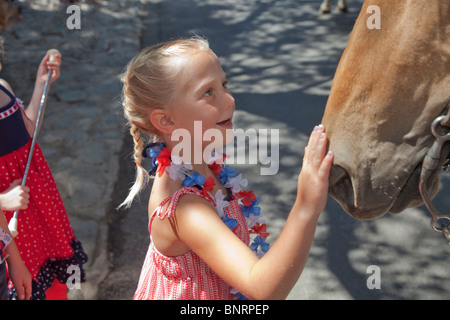 Con gli occhi spalancati sorridente sorriso sorrisi 5-6 anno vecchio petting amare ama soggezione fascino affascinato cavalli espressivo il Giorno di Indipendenza degli Stati Uniti MR Foto Stock