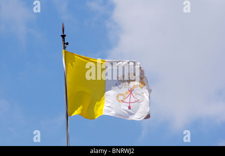 Vaticano bandiera contro il cielo nuvoloso Foto Stock