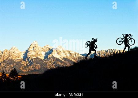 Un uomo e una donna la loro escursione in bici fino alla cima di una collina in Wyoming. Foto Stock