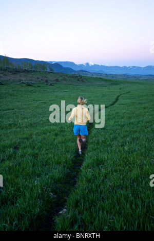 Una donna viene eseguito su un sentiero in Wyoming. Foto Stock