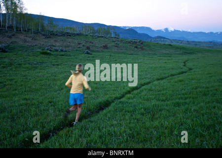 Una donna viene eseguito su un sentiero in Wyoming. Foto Stock