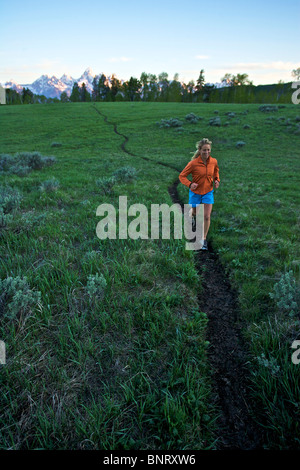 Una donna viene eseguito su un sentiero in Wyoming. Foto Stock