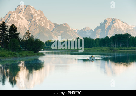 Una deriva di lone imbarcazione galleggia nel riflesso acque di un fiume. Foto Stock