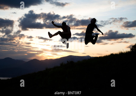 Due uomini saltando al tramonto in Idaho. Foto Stock