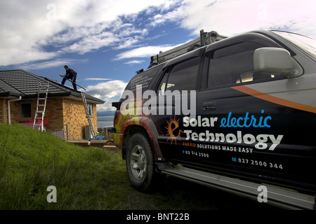 Artigiano qualificato installazione solare di acqua calda sistema a una casa, Nelson, Nuova Zelanda, la città con la più alta ore di sole Foto Stock