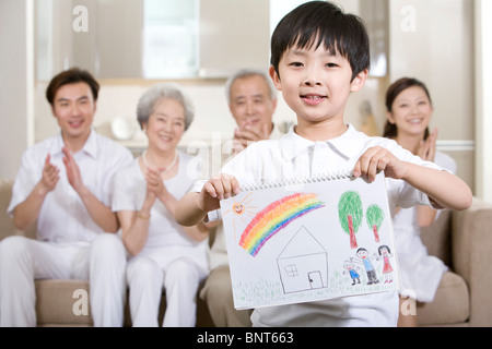 Little Boy può contenere fino a disegno nella parte anteriore della sua famiglia Foto Stock