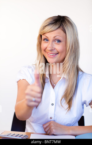 Bella imprenditrice con il pollice in su in ufficio Foto Stock