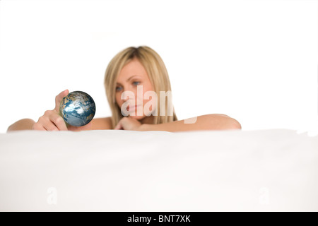 Donna radiante che mostra un globo Foto Stock