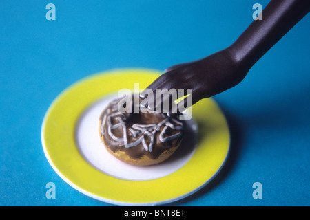 Barbie sta cercando una ciambella sul piatto. Foto Stock