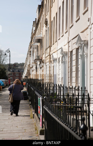 Una donna cammina passato a terrazza di un casa georgiana sulla West Mall, Clifton, Bristol, Inghilterra. Foto Stock