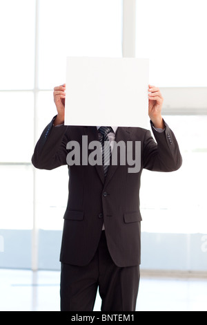 L'uomo tenendo un grande business card davanti al suo volto Foto Stock