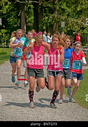 Queste squadre di teen ragazze sono in competizione in una tre gambe gara con uno di ciascuno di loro zampe legate insieme. Foto Stock