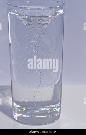Questa immagine di stock è un colpo di un alto, chiara, fresca e dissetante bicchiere di acqua vorticoso con un sacco di movimento e di bolle, appena ho Foto Stock