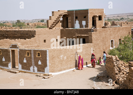 Donne verniciatura di una casa. Khuri villaggio. Il Rajasthan. India Foto Stock