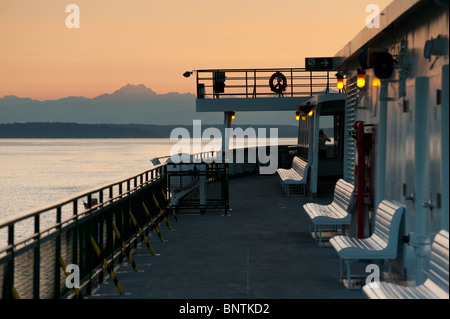 Una Stato di Washington traghetto rende il modo da Bainbridge Island a Downtown Seattle al tramonto. Montagne Olimpiche in background. Foto Stock