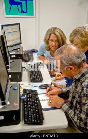 Gli anziani lavorano insieme ad un educazione degli adulti classe computer in San Juan Capistrano, CA. Nota notebook. Modello di rilascio Foto Stock