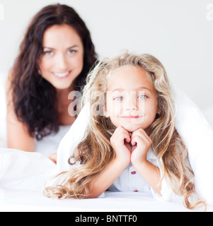 Affascinante madre e figlia abbracciando sul letto Foto Stock