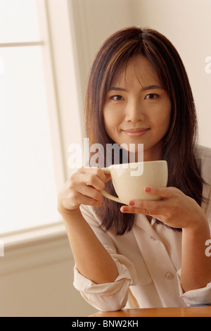 Donna attraente tenendo una tazza di caffè Foto Stock