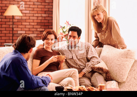 Quattro amici socializzazione in salotto Foto Stock