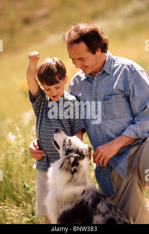 Padre figlio e cane in campo insieme Foto Stock