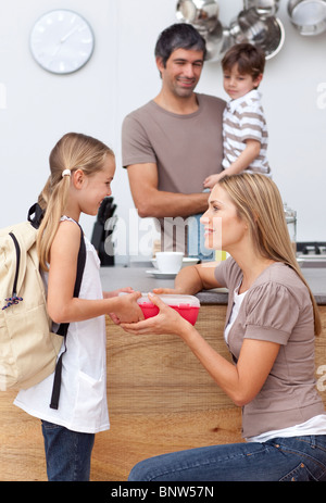 Madre di dare a sua figlia il pranzo a scuola Foto Stock