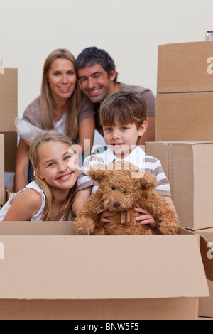 Bambini disimballaggio di scatole con i loro genitori Foto Stock