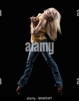 Donna bionda dancing mentre ascolti la musica sul lettore mp3 Foto Stock