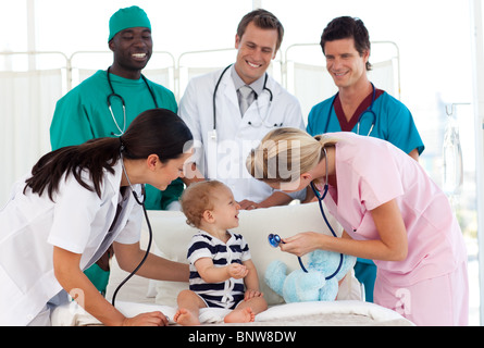 Il team medico di occuparsi di un bambino Foto Stock