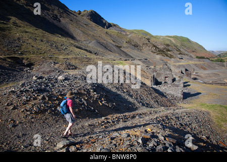 La donna gli escursionisti a piedi attraverso il bottino dei cumuli di rifiuti di pietra e resti di data mining a Cwmystwyth miniere di piombo Valle Ystwyth Wales UK Foto Stock