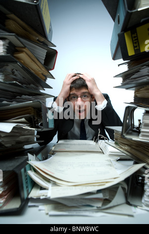 L uomo nella disperazione circondato con la documentazione Foto Stock