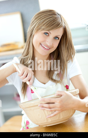 Ritratto di una donna carina che mostra una fetta di torta in cucina Foto Stock