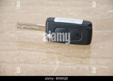 Le chiavi dell'auto, auto chiave (Peugeot) senza logo - con portachiavi - su marvel Foto Stock