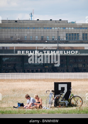 Le persone aventi picnic accanto alla pista di atterraggio a New city public Tempelhofer Park sul sito della ex aeroporto Tempelhof di Berlino Germania Foto Stock