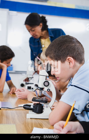 Gli studenti elementari utilizzando microscopi Foto Stock