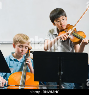 Gli studenti della scuola elementare a suonare strumenti musicali in classe Foto Stock