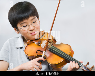 Scuola elementare studente suona il violino nella classe di musica Foto Stock