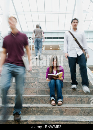 Gli studenti universitari in passi nella parte anteriore della libreria Foto Stock