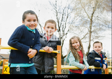 Gli studenti della scuola elementare a giocare nel parco giochi in corrispondenza del recesso Foto Stock