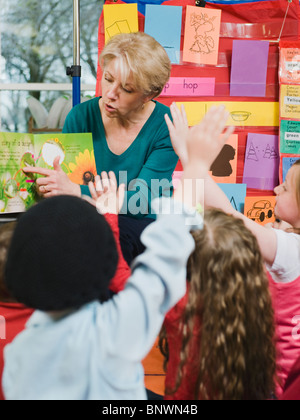 Insegnante di scuola elementare libro di lettura per gli studenti Foto Stock