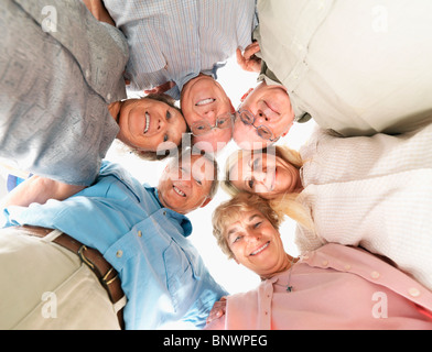 Un gruppo di persone raggomitolati insieme Foto Stock