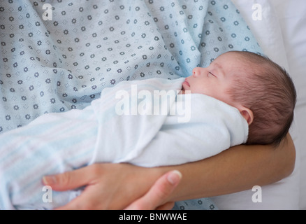 Neonato swaddles nella madre di braccia Foto Stock